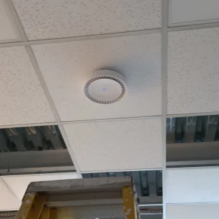 Access point WiFi empresarial instalado en el techo de las oficinas de Agronutrición