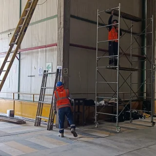 Técnicos sobre andamio instalando cableado de videovigilancia en la planta de Norandino