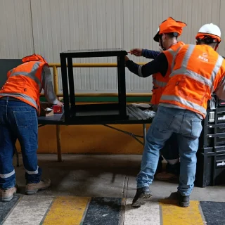 Técnicos armando el soporte metálico para cámaras en la planta de procesamiento de Norandino